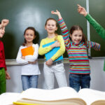 Portrait of five pupils having fun in classroom